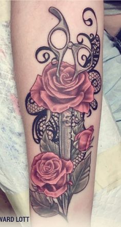 a tattoo with scissors and roses on it