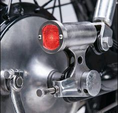 a close up of the front wheel of a motorcycle with a red light on it