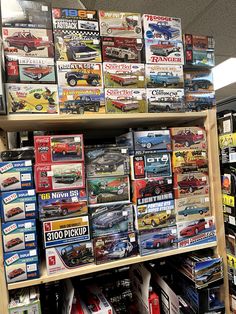 a display case filled with assorted model cars and trucks on top of wooden shelves