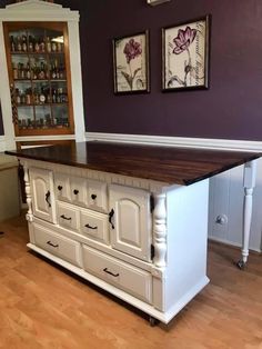 a large kitchen island with drawers in the center and two pictures on the wall above it