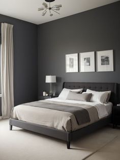 a bedroom with gray walls and white bedding in the center, along with two framed pictures on the wall