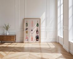 an empty room with white walls and wooden flooring has a framed wine bottle display on the wall