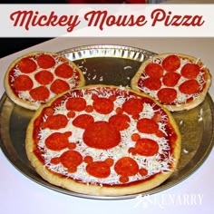 three pizzas with cheese and pepperoni on them sitting on a pan in the shape of mickey mouse