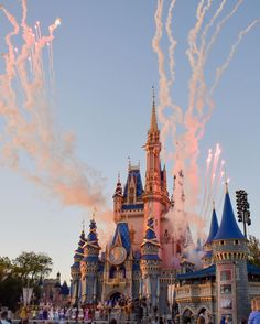 fireworks are lit up in the sky above disney's castle