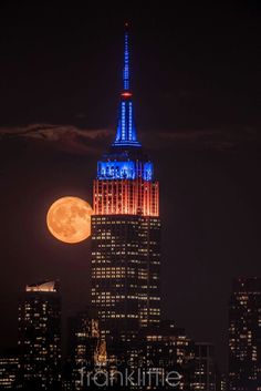 the empire building lit up in red, white and blue for new york's supermoon