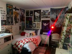 a bed room with a neatly made bed and lots of posters on the wall