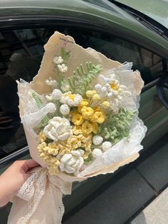 a person holding a bouquet of flowers in front of a car