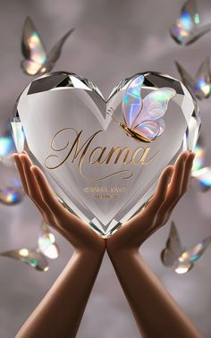 two hands holding a crystal heart with the words mama on it and butterflies flying around