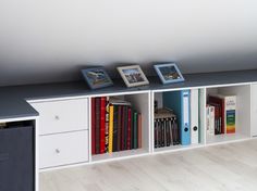 there are three bookshelves in the room with pictures on each shelf and two framed photos