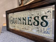 a framed sign that says guinness on it