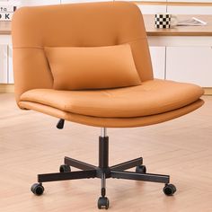 an office chair with wheels and a pillow on top of it in front of a desk