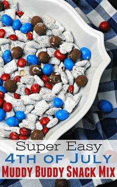 a white bowl filled with red, white and blue candy rocks on top of a checkered table cloth