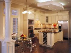 a kitchen with white cabinets and an island in front of a stove top oven next to a refrigerator freezer