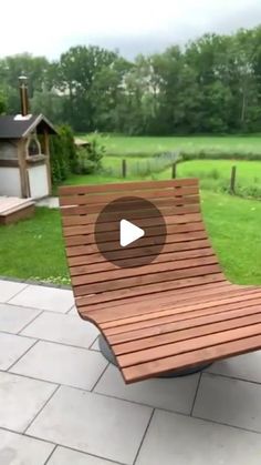 a wooden bench sitting on top of a stone floor next to a lush green field