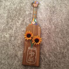 a wooden plaque with sunflowers in a mason jar