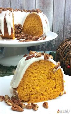 a pumpkin bundt cake with white frosting and pecans around it on a plate