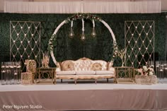 a couch sitting on top of a table next to a wall covered in greenery