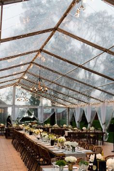 the inside of a large tent with tables and chairs set up for an outdoor event