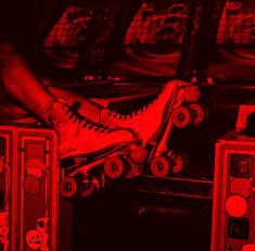 a person sitting on top of a skateboard in front of some speaker boxes with red lights