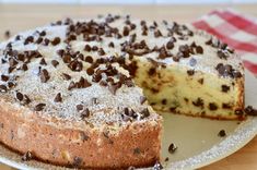 a chocolate chip cake on a plate with one slice cut out and ready to be eaten