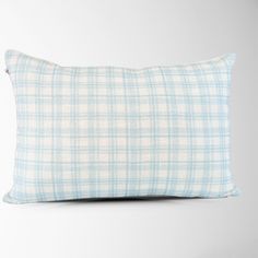 a blue and white plaid pillow sitting on top of a table