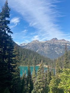 the mountains are covered in trees and blue water