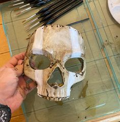 a person is making a skull mask out of clay