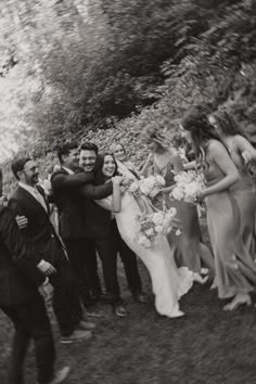 black and white photograph of bride and groom hugging each other in front of their wedding party