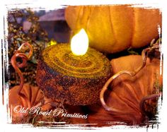 a candle that is sitting next to some pumpkins