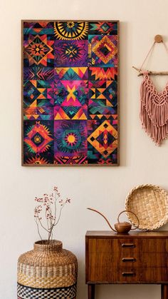 a painting hanging on the wall next to a table with a basket and plant in it