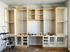 an empty room with shelves and ladders in the process of being built into the wall