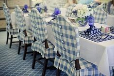 a dining room table set with blue and white checkered chair covers on the chairs