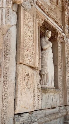 an ancient statue is shown on the side of a building