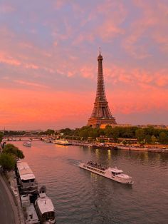 the eiffel tower towering over the city of paris, france at sunset with boats in the river below