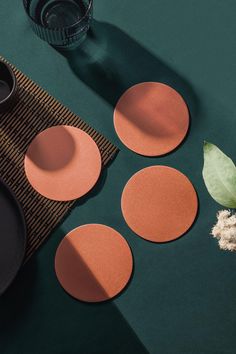 three round placemats sitting on top of a table next to a cup and saucer