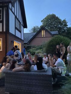 a group of people sitting around in front of a house