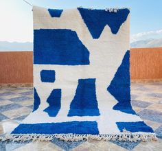 a blue and white rug on the ground