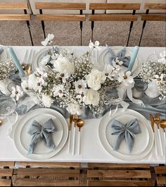 the table is set with silver and white flowers