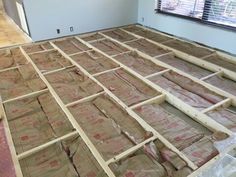 an unfinished room with wood flooring in the process of being installed and sealed up