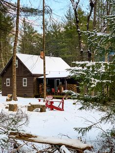 a cabin in the woods with snow on the ground