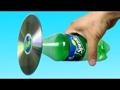 a hand holding a green bottle with a disc in it