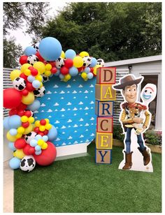 the balloon arch is decorated with toy story characters and balloons that spell out dad's day