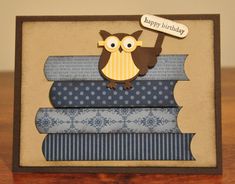 a birthday card with an owl on top of stacks of folded books and a sign that says happy birthday