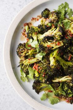 a white plate topped with broccoli covered in seasoning