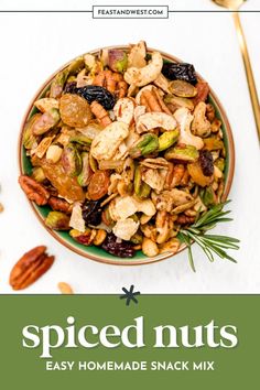 a bowl filled with nuts and vegetables next to a spoon on top of a table