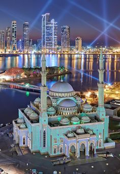 an aerial view of a large building in the middle of a body of water at night