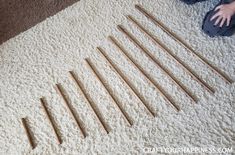 a child is playing with wooden dows on the floor in front of a carpet