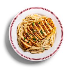 a white plate topped with pasta covered in chicken breast and parmesan cheese sauce