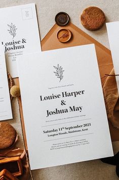 the wedding stationery is laid out on top of brown envelopes and other items