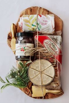 an assortment of cheeses and condiments on a wooden platter